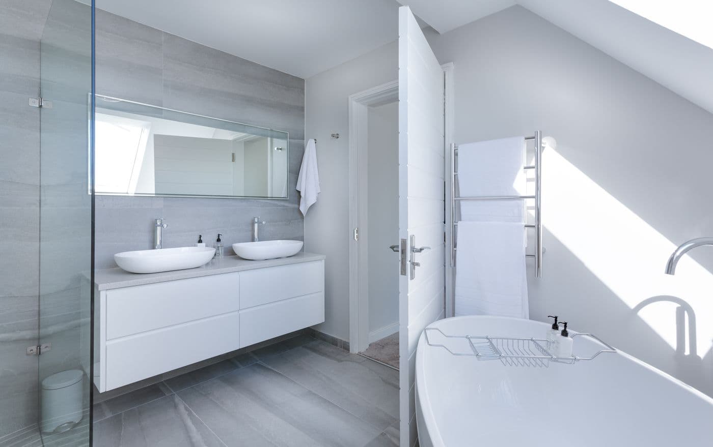 Modern bathroom with grey tile, grout lines, and a white vanity